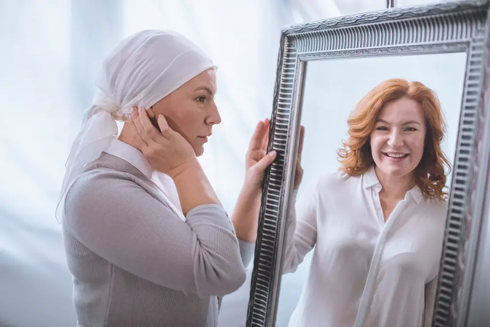 women looking at the mirror for her past imagine and her current state after chemotherapy 