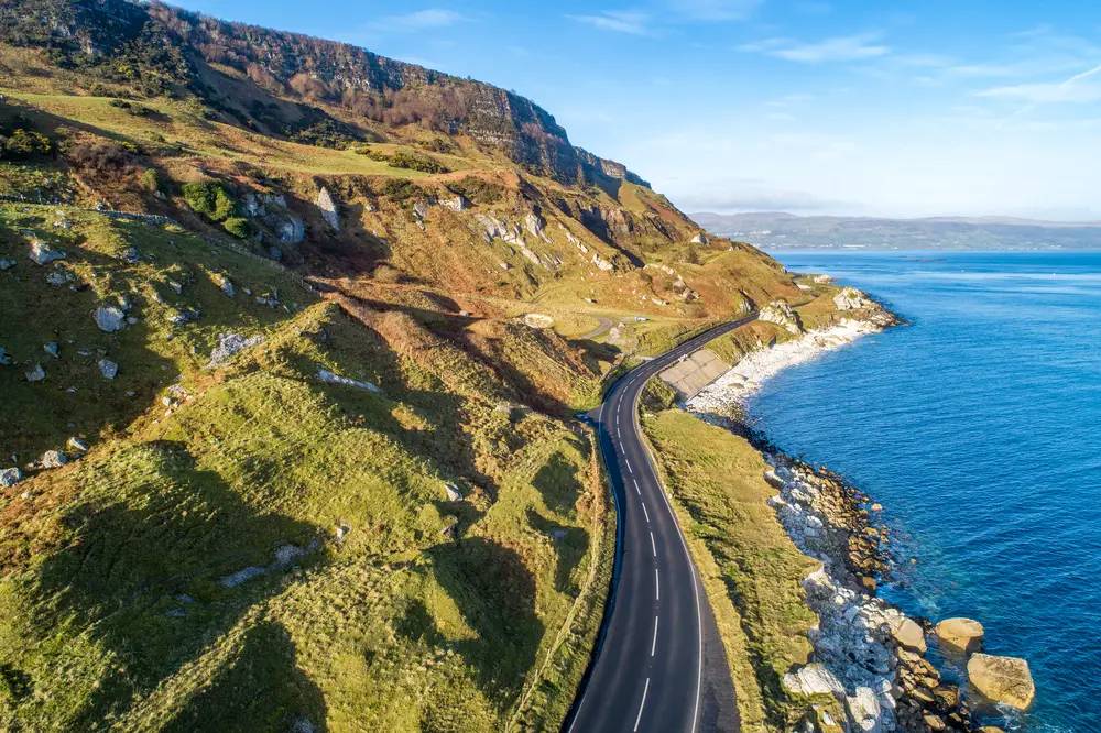 he eastern coast of Northern Ireland and Causeway Coastal Route a.k.a Antrim Coast Road A2. One of the most scenic coastal roads in Europe. Aerial view in winter 